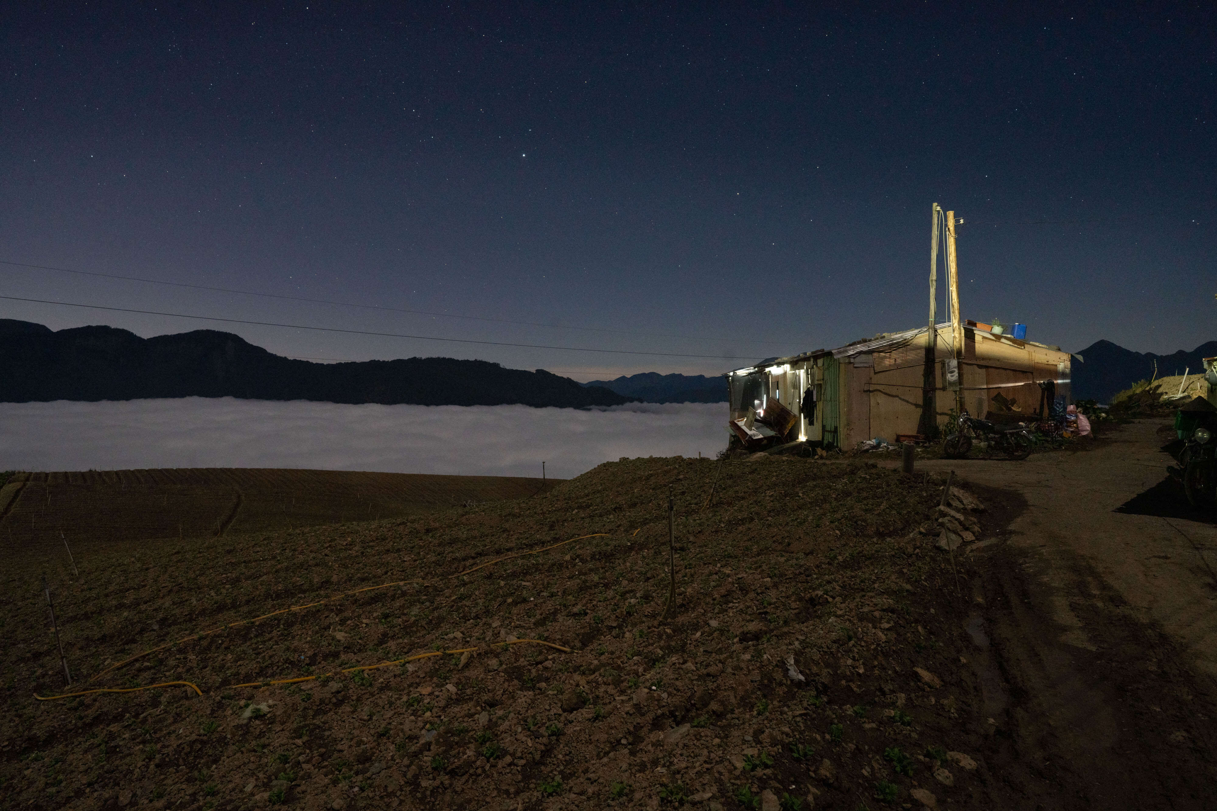 華南雲雨帶通過後，海拔2400公尺的山區出現美麗雲海，持續到晚間仍未散去，但是山上氣溫低，加上在田裡工作一天後，他們寧可待在工寮內避寒。