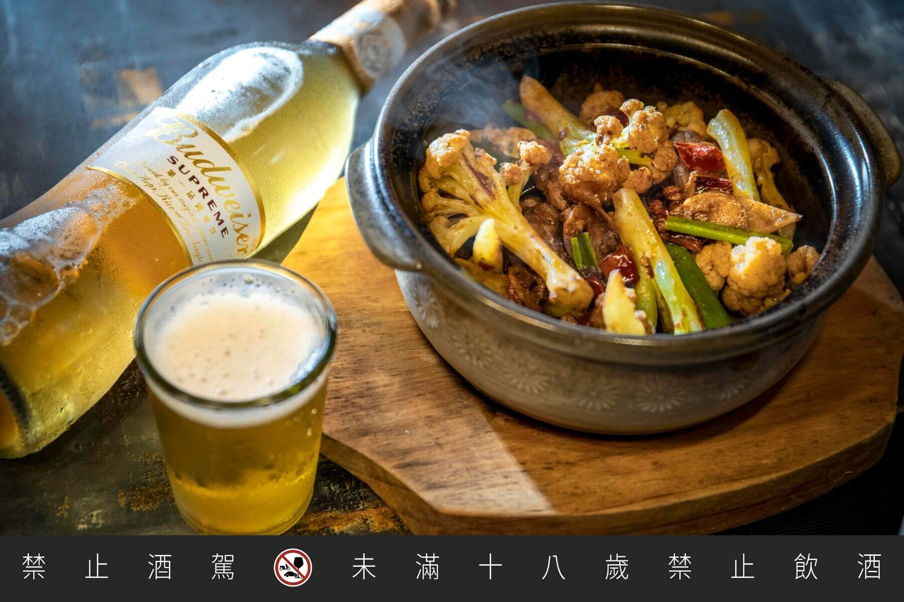 老撈麻辣鍋的私房熱炒——乾鍋花椰菜，花椒麻香帶勁，與百威金尊搭出鹹香辣鮮多重滋味。