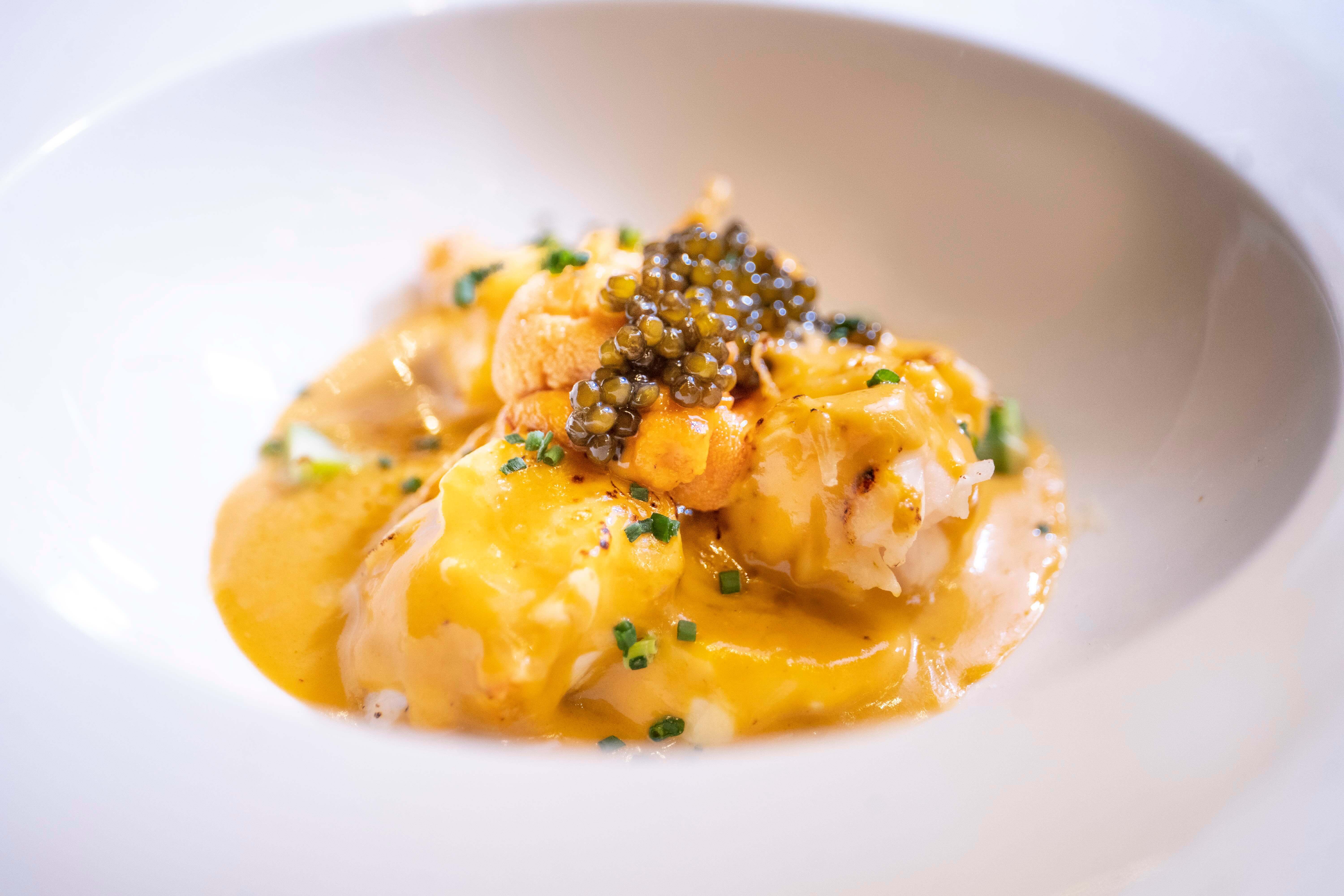 〈澳洲龍蝦．赤海膽．法國魚子醬〉底層是鹹味烤布蕾，口感如同嫩滑的蒸蛋，上層覆以焗白菜風味的海膽醬汁，再鋪上龍蝦塊與綠蘆筍，最後撒上帕瑪森起司與糖，經高溫焗烤至金黃酥脆。