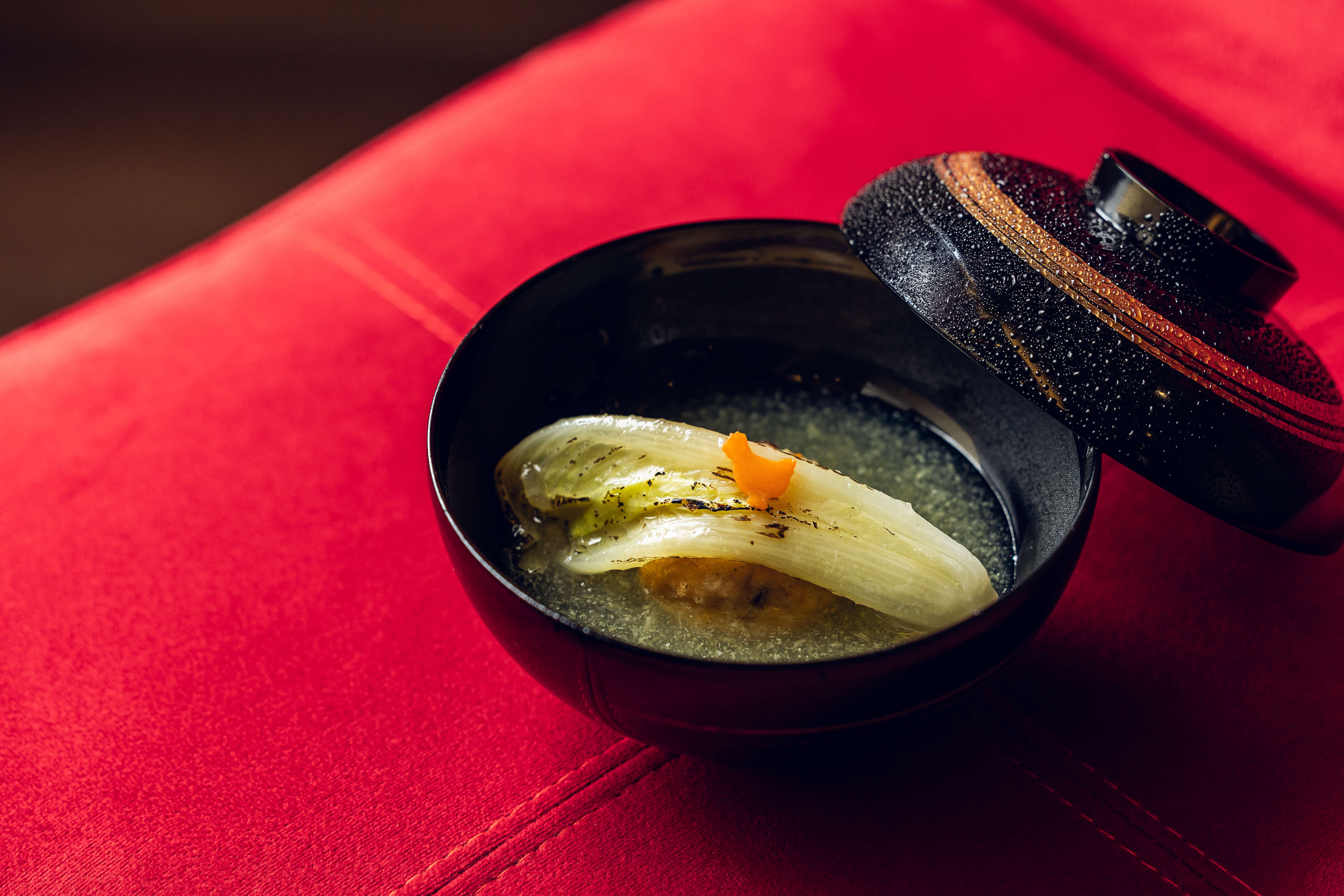 「飛龍頭佐白菜霙煮」在碗蓋上噴水霧，據說源於古代貴族不喜他人碰觸自己的皿食，同時也能起到監測的作用。圖片提供／鳥力TORICHIKARA