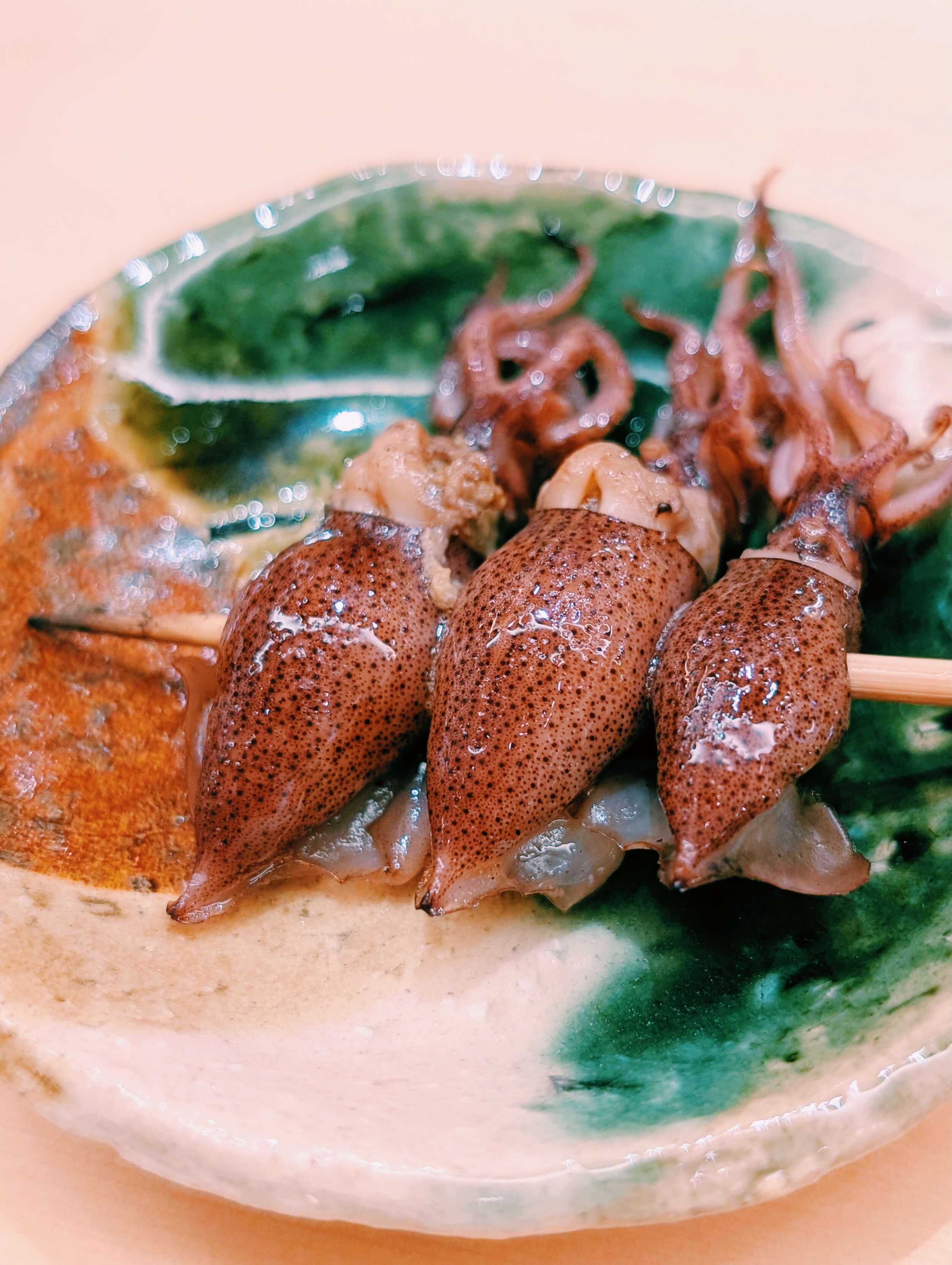 當季的日本富山螢烏賊，經過精準火候的炭火烤製，外層微微焦香，一咬迸出內臟深邃而獨特的鮮香。攝影／高麗音