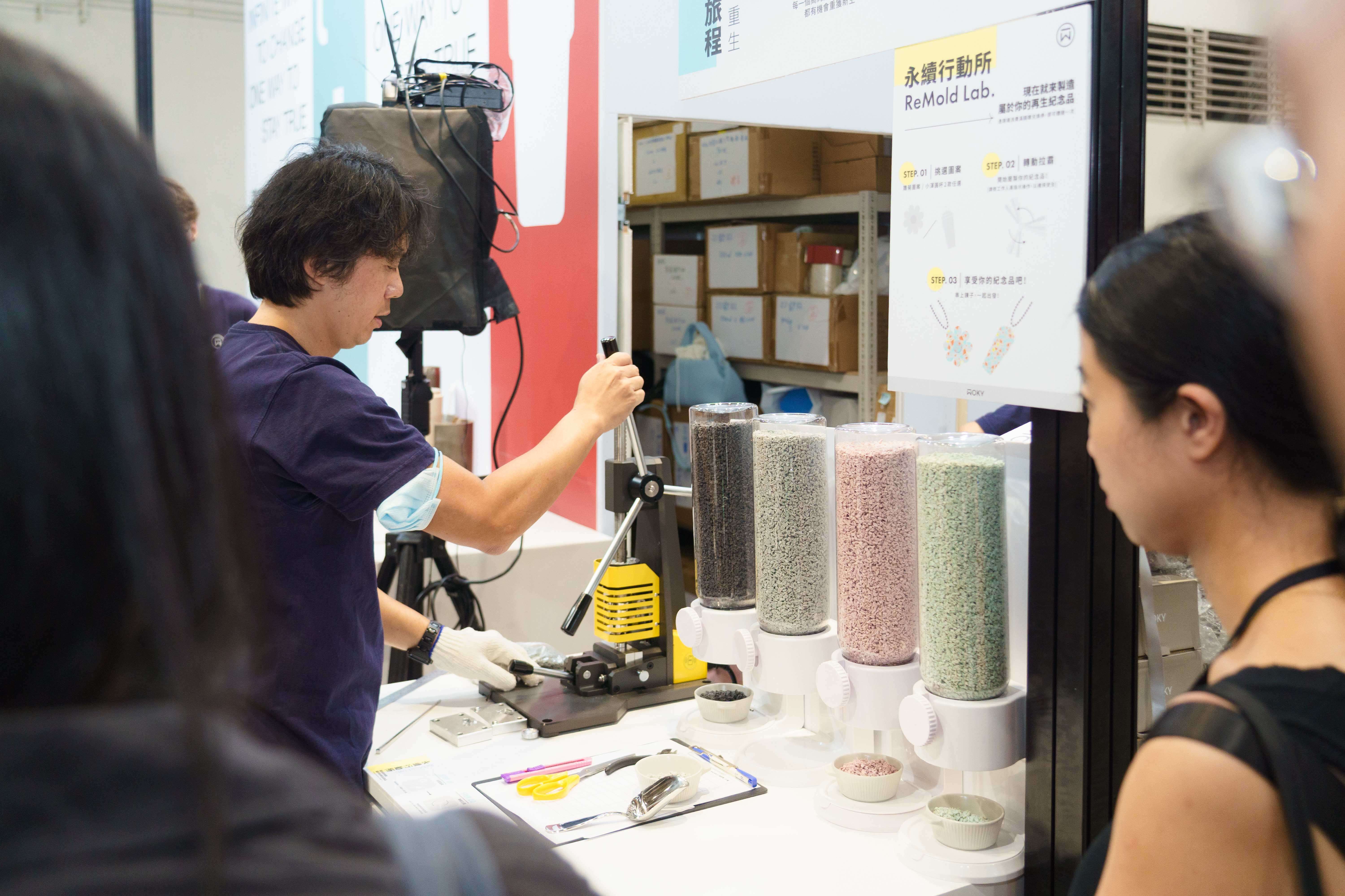 WOKY展攤展示前幾代高純度塑料杯蓋，經注塑機粉碎、高溫熱壓，轉化為循環美學設計擺件。