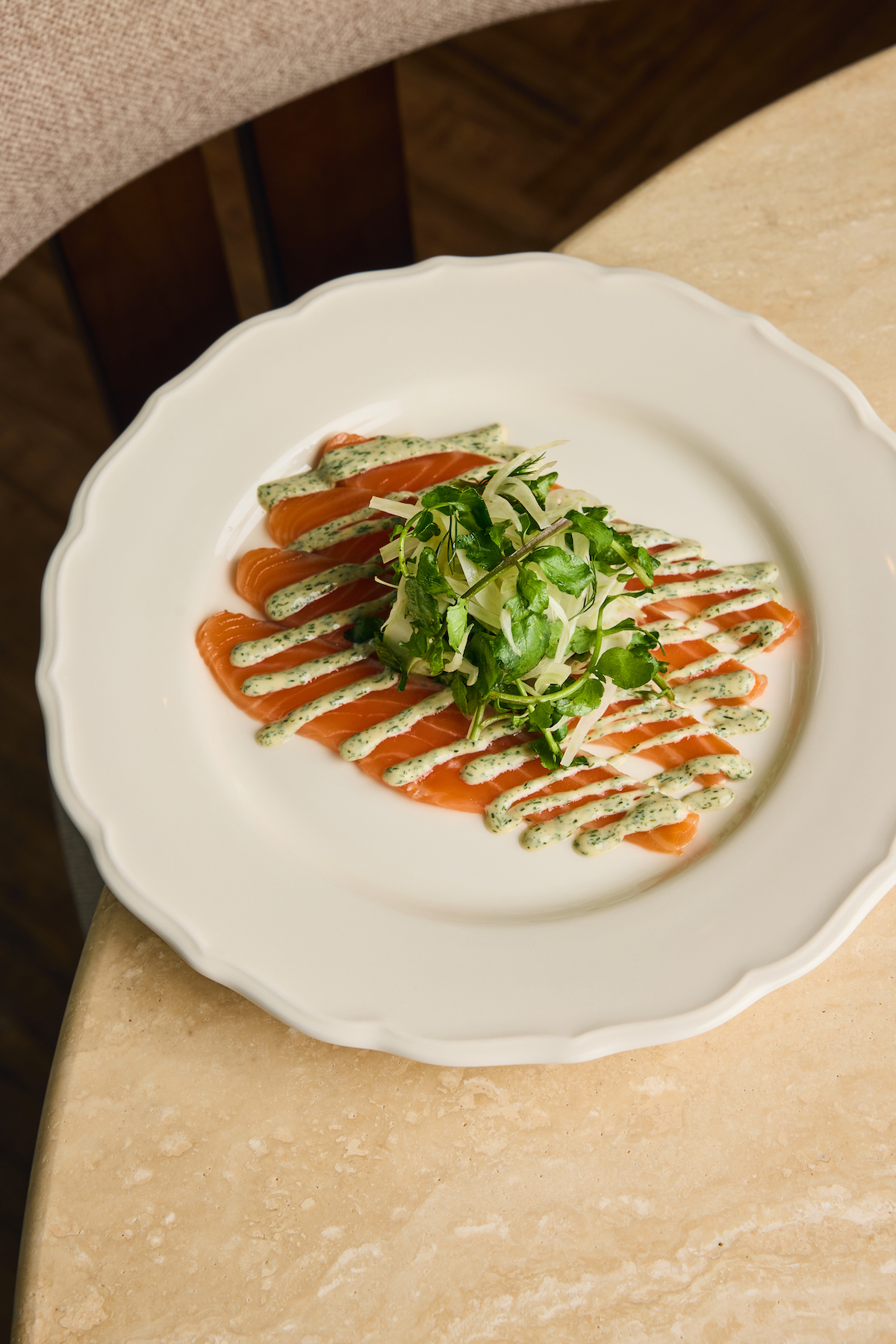 以花苞狀的整顆朝鮮薊搭配濃鬱大蒜鯷魚醬（左）；鮮嫩鮭魚預先以蒔蘿、海鹽與糖細緻醃漬，加入檸檬及茴香帶來深刻美味（右）。