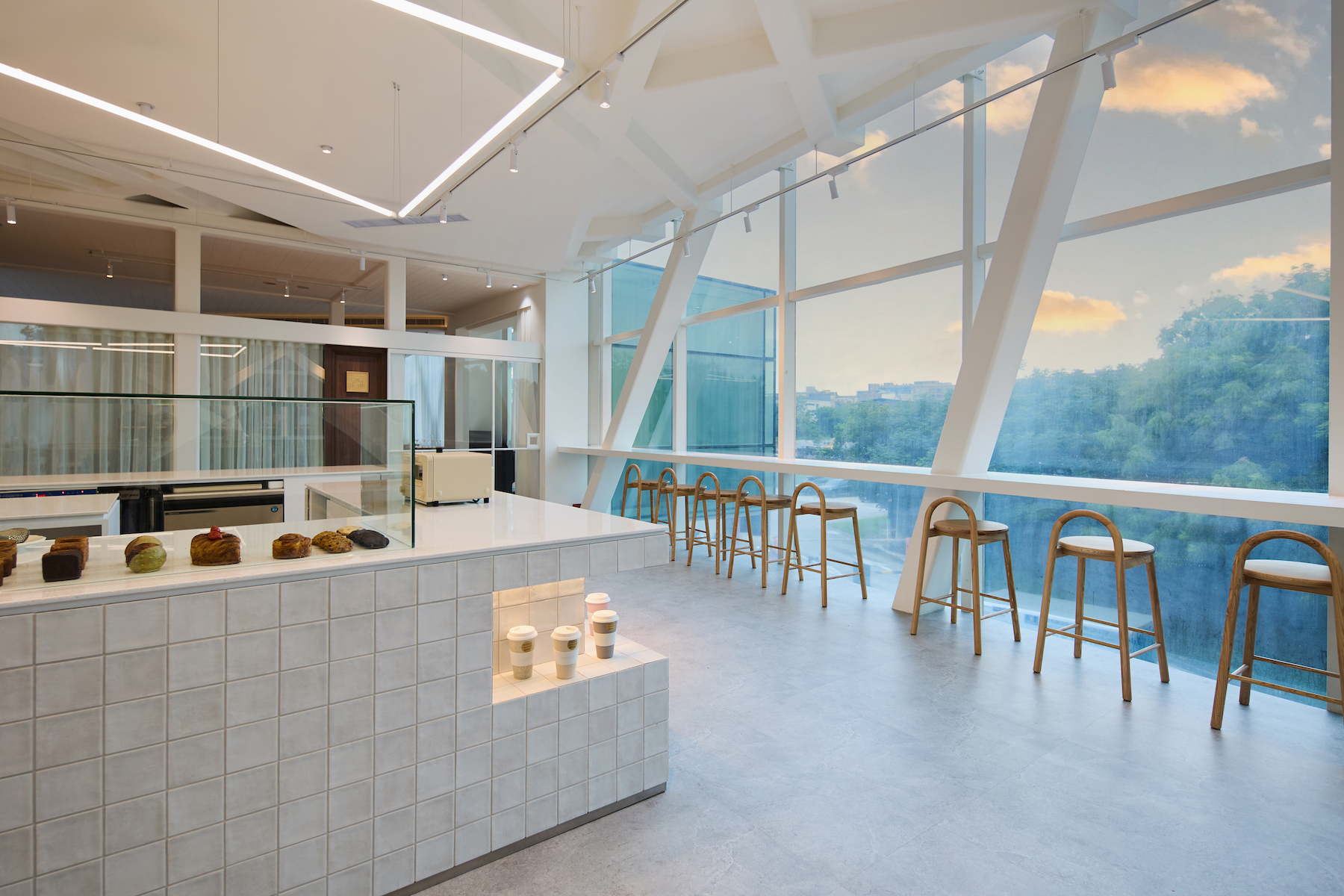 Rolling Dough 咖啡廳座位區擁有臺北市區少見的低空航道景觀，提供「北美館看飛機」的絕佳視角。