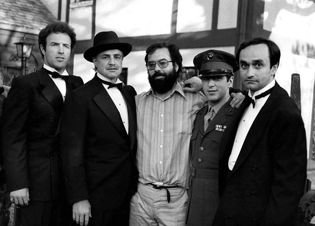 由左至右分別為詹姆士•肯恩（James Caan）、馬龍•白蘭度（Marlon Brando）、《教父》導演法蘭西斯•柯波拉 （Francis Coppola）、艾爾• 帕西諾 （AI Pacino）、約翰• 卡佐爾（John Cazale）