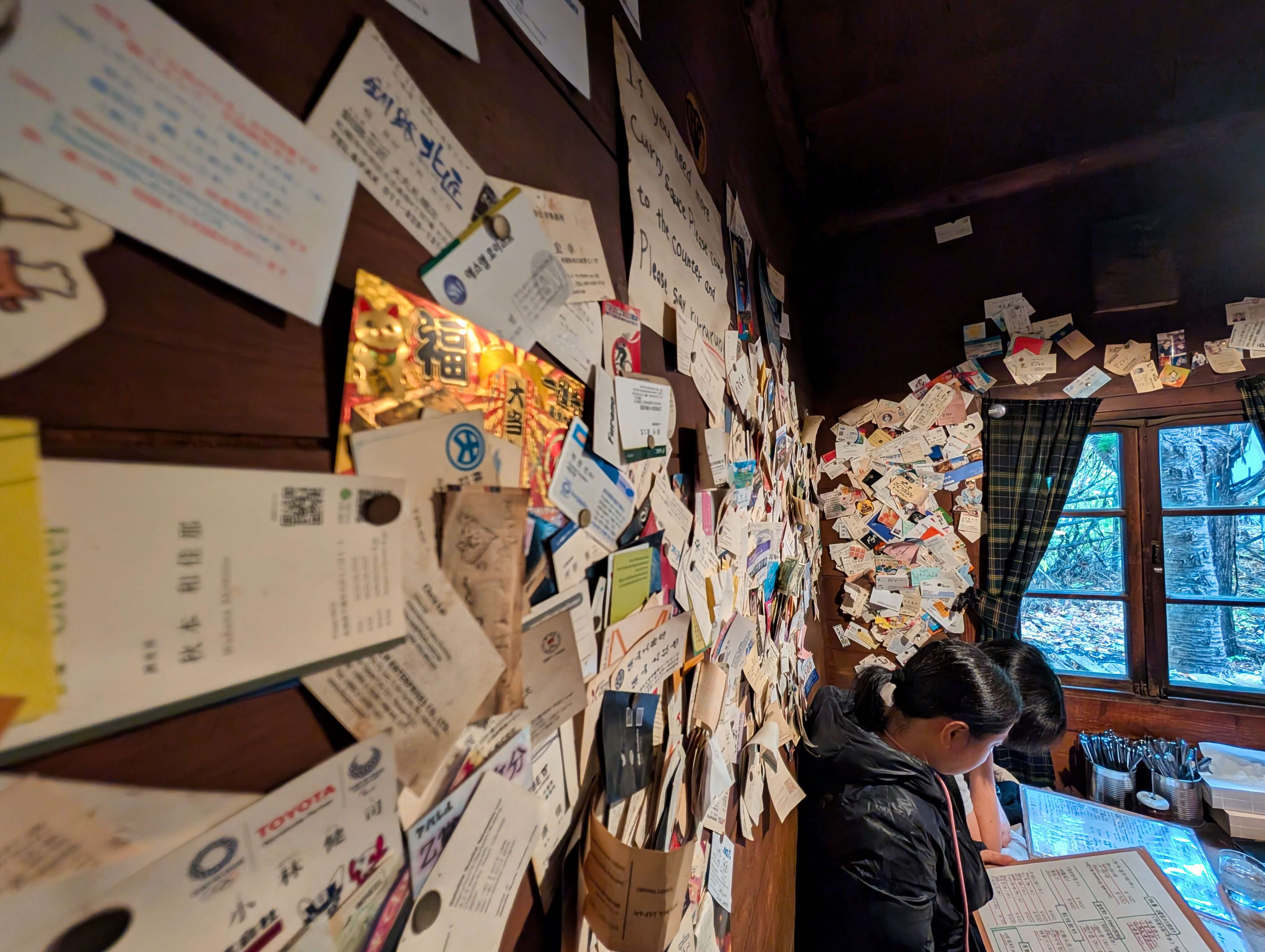 店內牆面貼滿來自世界各地客人的名片。