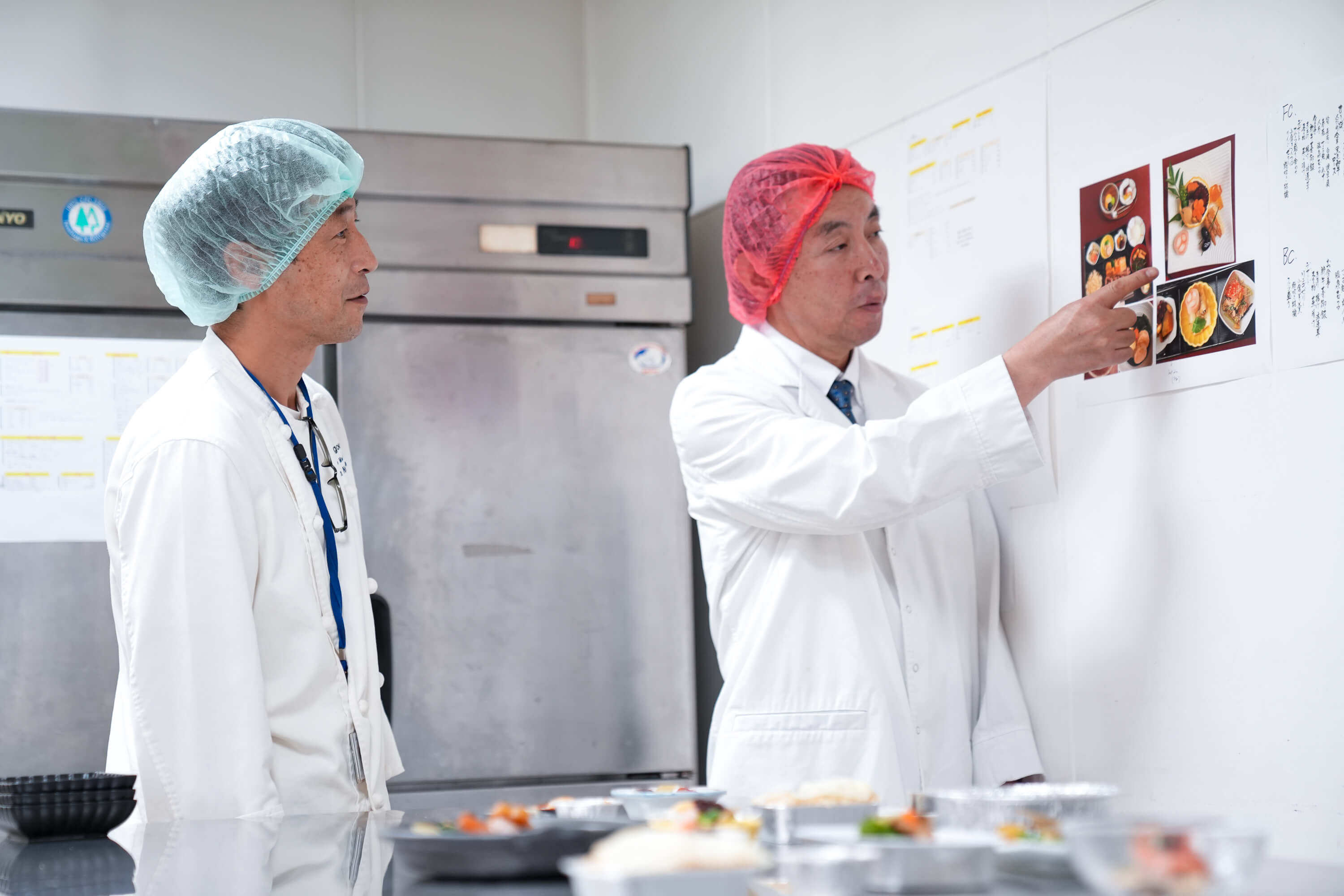 佳美航空膳食日式料理主廚仲嶺隆（左）與人形町今半本店總料理長青木勝利（右），研究機上套餐的風味與擺盤。