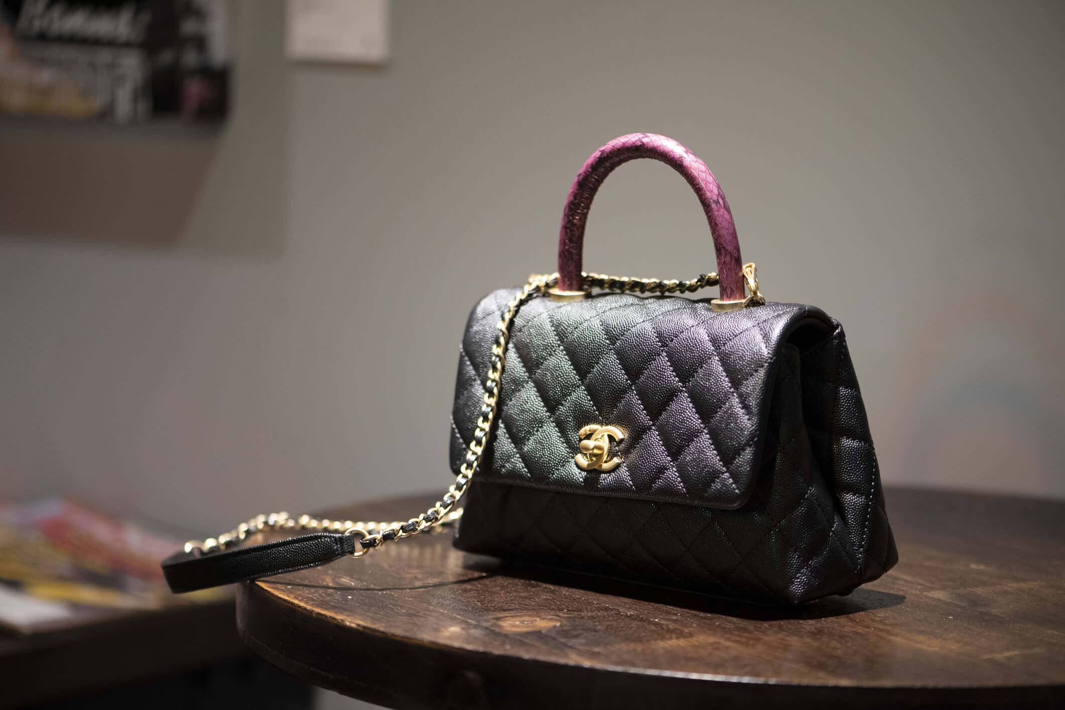 卡爾·拉格斐設計的香奈兒手袋，配有粉紅色蟒蛇皮手柄和金色飾件。