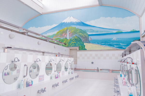 挑高的木造屋頂下，富士山壁畫靜靜映照著氤氳湯氣。©小杉湯