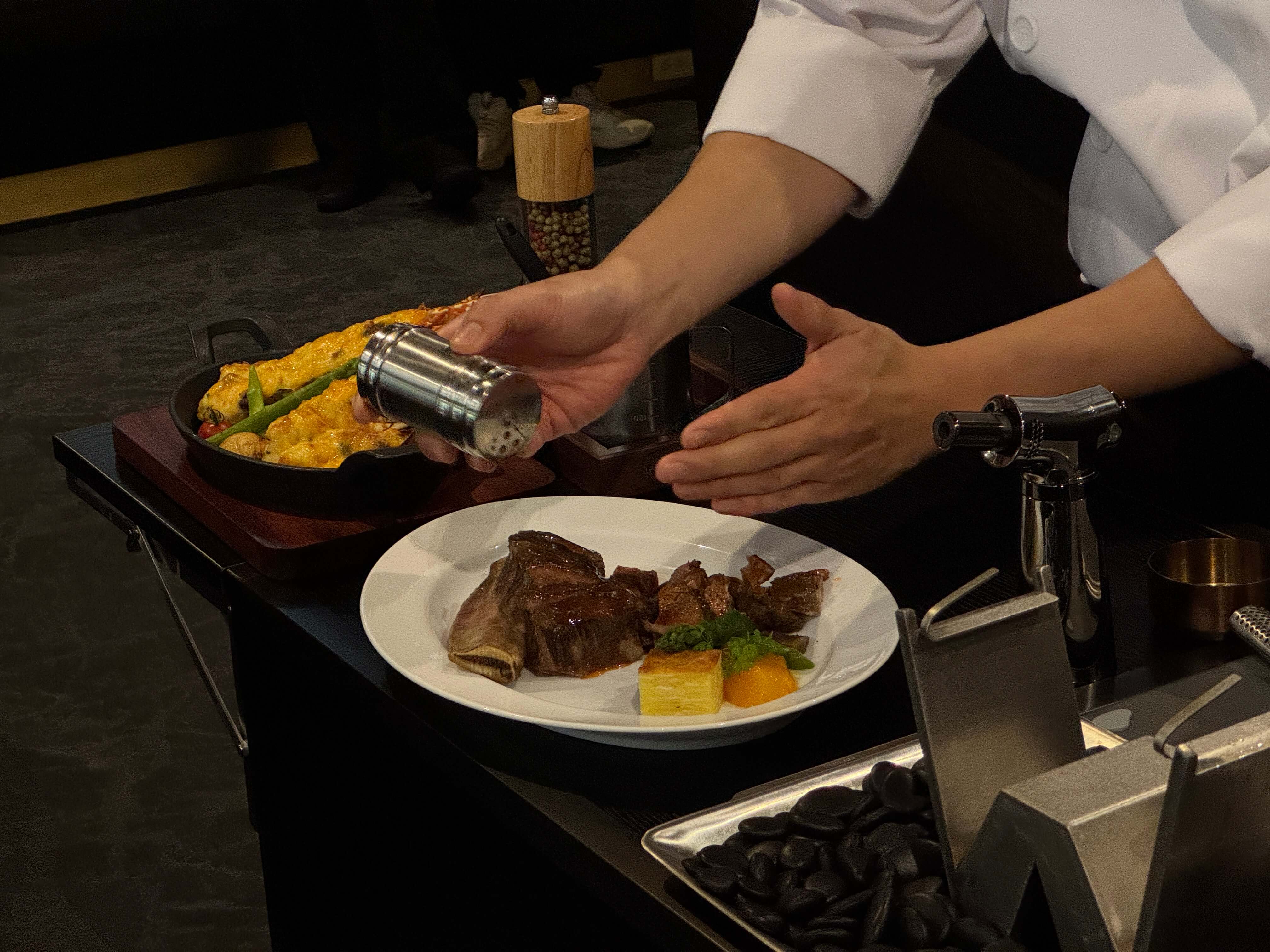 桌邊白蘭地烈焰封香經典王品牛小排，封存香甜飽滿肉汁，佐以整隻龍蝦，金黃柔軟的焗烤起司，包覆彈牙與甜美，劇場般的儀式感，為難得時刻，演出最盛大的難忘場景。攝影/鄭琮諺