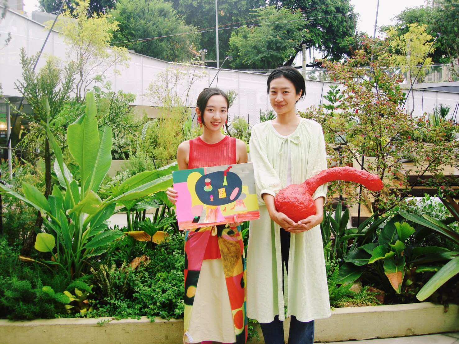 PARK2 策展人 Jin（張景涵）與旅英藝術家 Walkthecatt 合影，兩人攜手將麵包、水果與紙雕塑融入現場，打造跨越餐食與美學的沉浸式藝術長餐桌 (PARK2提供)。