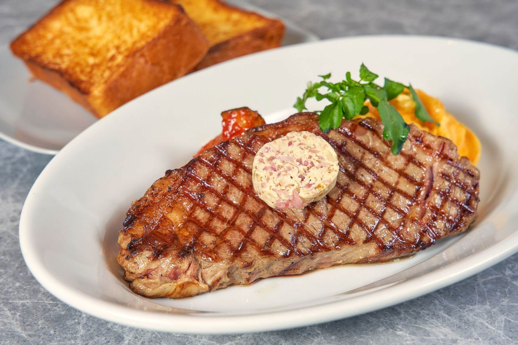 美國Prime紐約客牛排佐以焦化甘蔥奶油。