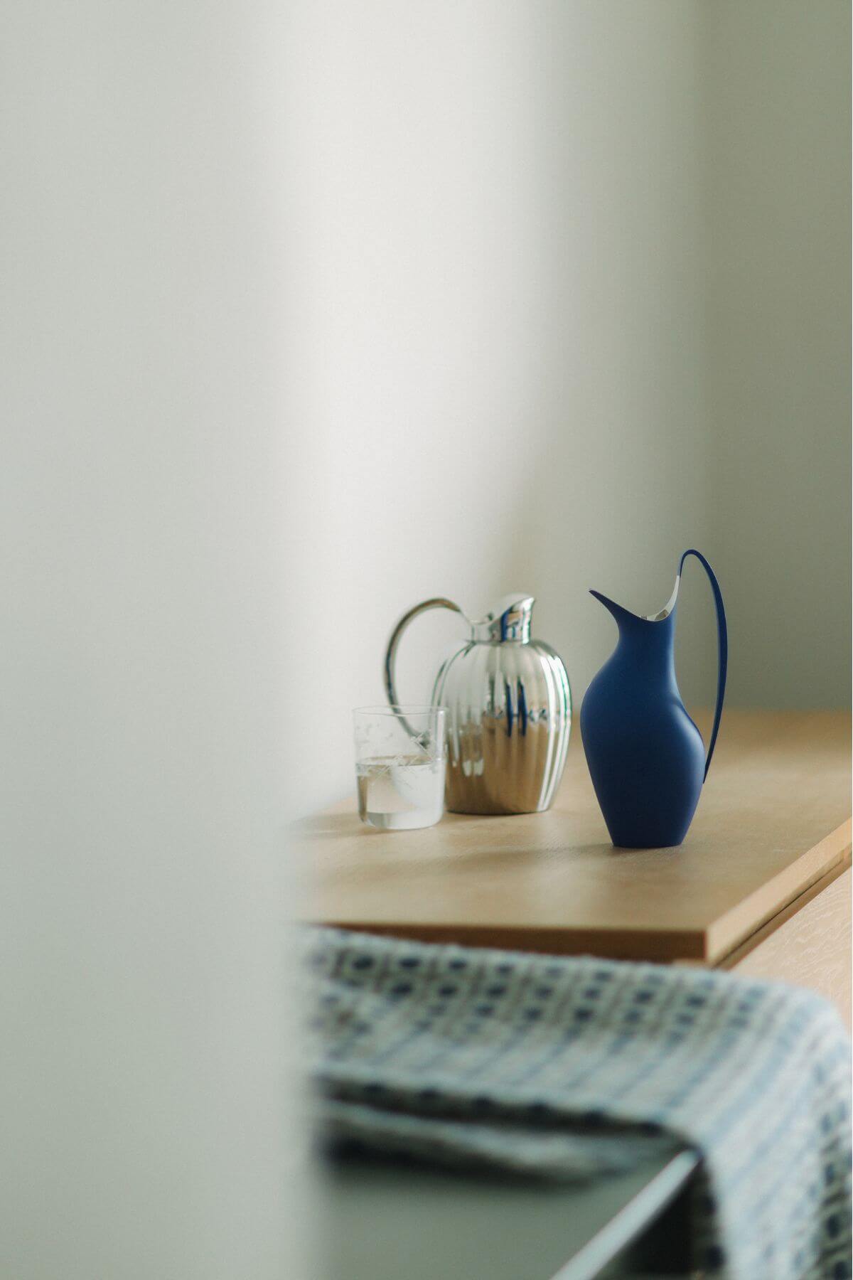 圖 ∕ （由左至右）Bernadotte 鏡面拋光不鏽鋼水瓶、Koppel 經典藍水瓶 by Georg Jensen。